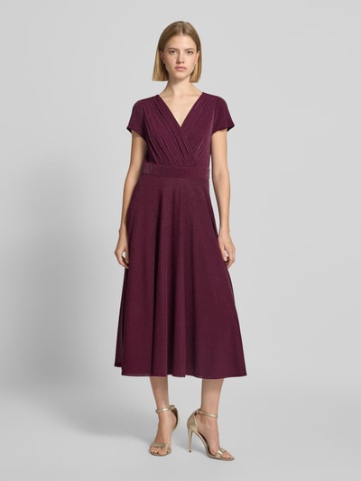Frauenmodel trägt Tailliertes Cocktailkleid mit V-Ausschnitt von Vera Mont in dunklem Bordeauxrot, feine Glitzertextur, Ganzkörperansicht von vorne, Damen Cocktailkleid von Vera Mont.