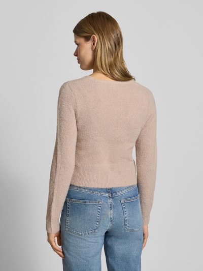 Frauenmodel trägt Slim Fit Strickjacke mit einreihige Knopfleiste Modell 'KERRY' von Only, Optik: Unifarben, Materialverarbeitung: Strick, Langarm, Rumpfabschluss und Ärmelabschluss gerippt, Label Patch, Ganzkörperansicht Rückansicht.