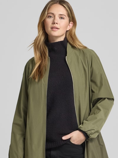 Frauenmodel trägt Mantel mit Stehkragen und Zweiwege-Reißverschluss von Fuchs Schmitt in Olivgrün, Material-Mix, Nahaufnahme Oberkörper.
