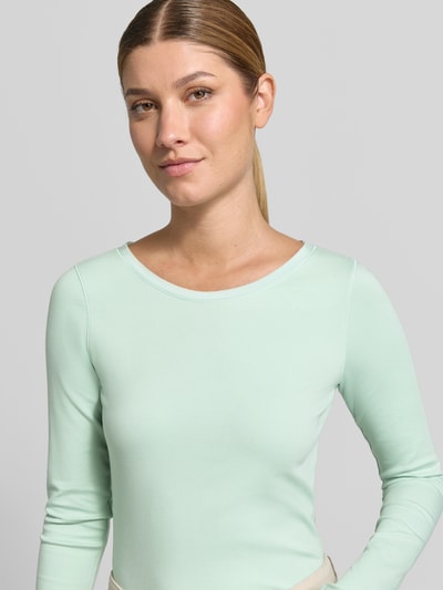 Modelka kobieca nosi Longsleeve aus Baumwoll-Mix od Marc Cain, mieszanka bawełny i elastanu, krój slim fit, okrągły dekolt, krój z długim rękawem, długość tyłu w rozmiarze 36: 50 cm, kolor pastelowej mięty, gładka faktura, zbliżenie na górną część ciała, przód