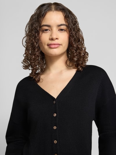 Kobiece model prezentuje kardigan Regular Fit Cardigan mit Viskose-Anteil Modell 'Compact' von Topshop, mieszanka bawełny i wiskozy, imitacja dzianiny, dekolt w serek, kolor czarny, widoczna faktura materiału, zbliżenie na górną część ciała, Nahaufnahme Oberkörper.