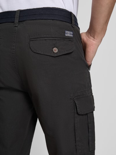 Mężczyzna nosi Regular Fit Bermudas mit Cargo-Taschen od Petrol, czarne bermudy z bawełny, kieszenie cargo, długość wewnętrzna nogawki 27 cm, szerokość w rozmiarze M: 45 cm, z tyłu kieszeń z patką, detal tyłu, zbliżenie na pośladki.
