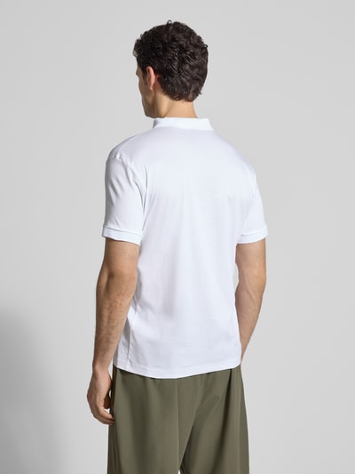 Männermodel trägt weißes Regular Fit Poloshirt aus reiner Baumwolle Modell 'PS Spirit 70 Plk' von BOSS Green X PORSCHE, Rückenansicht.