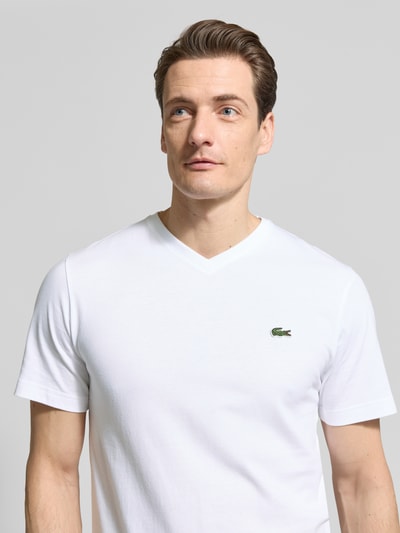 Männermodel trägt Regular Fit T-Shirt aus reiner Baumwolle von Lacoste, Optik: Unifarben, Logo-Stitching, V-Ausschnitt, Kurzarm, Nahaufnahme Oberkörper.