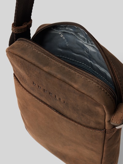 Produktfoto, Umhängetasche aus echtem Leder mit Label-Detail Modell 'Luca' von bugatti in Braun mit Reißverschluss und verstellbarem Schulterriemen, glatte und matte Textur, Detailaufnahme, Herrenaccessoire