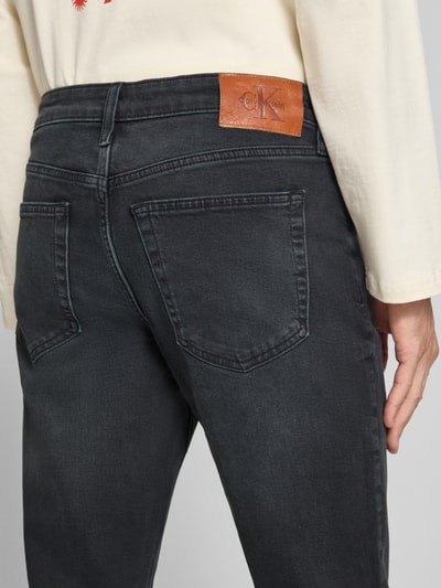 Männermodel trägt dunkelgraue Slim Fit Jeans aus Baumwoll-Mix Modell 'MIDNIGHT EMERALD' von Calvin Klein Jeans, Nahaufnahme Rückansicht.