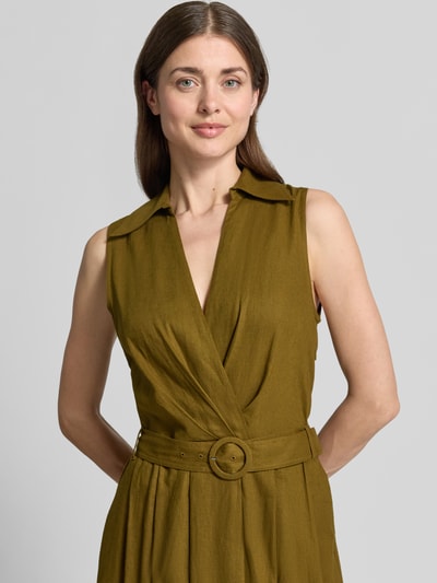Frauenmodel trägt Maxikleid aus Leinen-Viskose-Mix mit Gürtel von Stefanel in Olivgrün, Wickel-Optik, Nahaufnahme Oberkörper.