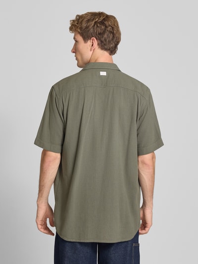 Männermodel trägt Regular Fit Freizeithemd aus reiner Baumwolle von G-Star RAW in Olivgrün, lockere Passform, Ganzkörperansicht Rückansicht.