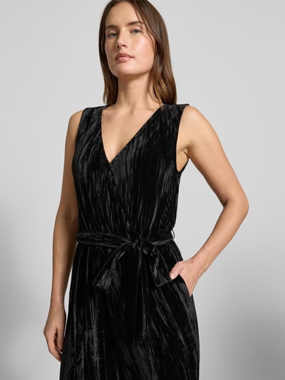 Frauenmodel trägt Regular Fit Jumpsuit aus Samt von Tom Tailor Denim in Schwarz mit V-Ausschnitt, Gürteldetail, Nahaufnahme Oberkörper.
