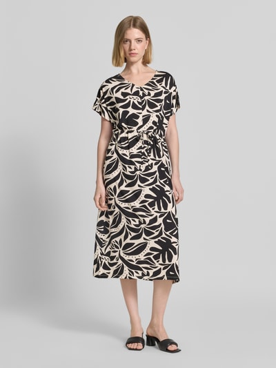 Frauenmodel trägt Damen Midikleid mit Kordelzug und V-Ausschnitt Modell 'MARICA' von Soyaconcept, Schwarz-Beige Muster, Lyocell-Mix mit Stretch-Anteil, taillierter Schnitt, Rückenlänge bei Größe S 117 cm, Brustweite bei Größe S 57 cm, Ganzkörperansicht von vorne.