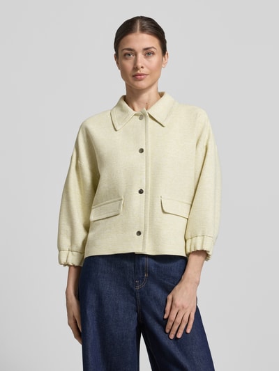 Vrouwenmodel draagt Regular Fit jack met viscose van More & More in lichtgeel met structuurpatroon, klepzakken en 3/4-mouw, voorkant bovenlichaam.