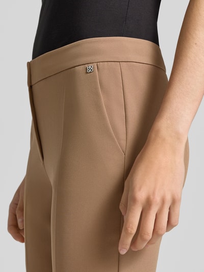Frauenmodel trägt Schmale Hose mit Label-Detail Modell 'Hagonia-1' von HUGO in Beige, glatte Struktur, Detailaufnahme, Damen Schmale Hose von HUGO