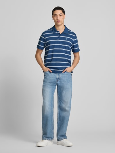 Männermodel trägt Regular Fit Poloshirt mit Logo-Stitching von Calvin Klein Jeans, Reine Baumwolle, Polokragen, kurze Knopfleiste, Rückenlänge bei Größe M 69 cm, Ganzkörperansicht von vorne.