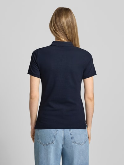 Vrouwenmodel draagt Slim Fit poloshirt met labelstitching van Gant, donkerblauw, mix van katoen en elastaan, knoopsluiting, ruglengte maat S 59 cm, slim fit, rugaanzicht, ganzkörperansicht rugaanzicht.