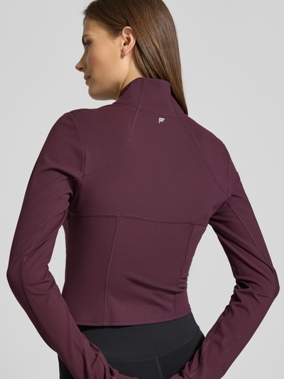 Modelka nosi Slim Fit Jacke mit Stehkragen Modell 'Storm' von Fabletics, kolor bordowy, pętelki na kciuki, krój krótki, długość tyłu 44 cm, szerokość ramion 36 cm, szerokość w rozmiarze S: 42 cm, długość rękawów 74 cm, widok całej sylwetki z tyłu