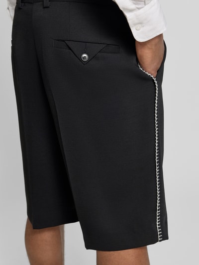 Mężczyzna nosi Regular Fit Chinoshorts mit Schurwoll-Anteil Modell 'FERY262F1X' von HUGO, efekt: jednolity kolor, kanty, szwy, wpuszczane kieszenie, mieszanka materiałów z dodatkiem żywej wełny, pikowana struktura, zapięcie na haftkę i zamek błyskawiczny, czarny kolor, detal: ozdobne szwy po bokach, ujęcie: z tyłu, wąska perspektywa