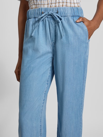 Frauenmodel trägt Wide Fit Hose aus Lyocell-Mix mit Tunnelzug von Christian Berg Woman, hellblaue Farbe, glatte Textur, Nahaufnahme Oberkörper. Damenhose mit elastischem Bund, weitem Schnitt und Baumwoll-Anteil im Bildkontext.