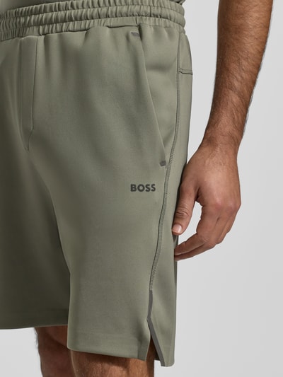 Männermodel trägt Regular Fit Sweatshorts aus schnell trocknendem Gewebe Modell 'HECON ACTIVE' von BOSS Green in Unifarben mit Label-Patch, Tunnelzug, elastischem Beinabschluss, seitlichen Eingrifftaschen, Gesäßtasche und Stretch-Materialverarbeitung, Nahaufnahme Oberschenkel.