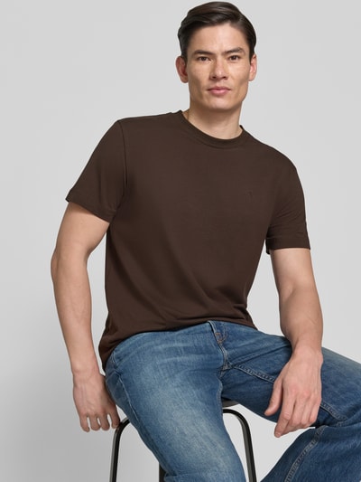 Męski model nosi T-Shirt mit Rundhalsausschnitt Modell 'Carlonito' od JOOP! Collection, bawełniany miks ze stretchem, krój straight fit, detal z logo, długość tyłu w rozmiarze M: 71 cm, kolor brązowy, jednolita faktura, całe ciało z przodu