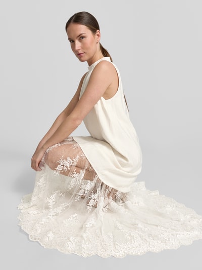 Kobiece model prezentuje Relaxed Fit Maxikleid aus Viskose-Mix Modell 'Tenley' od Copenhagen Muse, koronkowe detale, beż i biel, półprzezroczysta tekstura, damska sukienka maxi, widok całej sylwetki z przodu