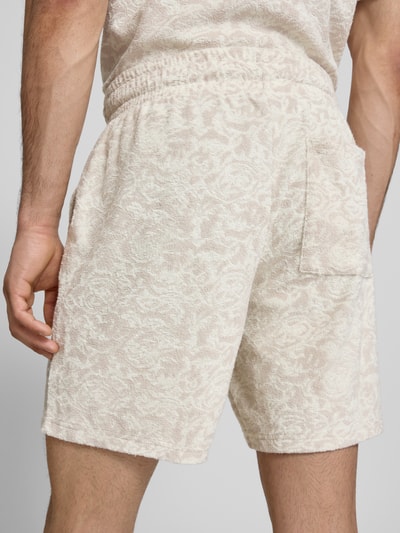 Männermodel trägt Relaxed Fit Sweatshorts mit Baumwoll-Anteil Modell 'CLEMENT' von Only & Sons, Frottee, cremefarbenes Allover-Muster, elastischer Bund, seitliche Taschen, Ganzkörperansicht Rückansicht.