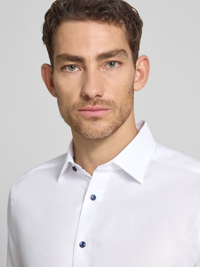 Männermodel trägt Regular Fit Business-Hemd in unifarbenem Design mit kentkraag van OLYMP aus puur katoen, nahaufnahme oberkörper. Context: heren zakelijk hemd van puur katoen, regular fit, model 'New Kent', effen design, kentkraag, ruglengte bij maat 40: 71 cm, schouderbreedte bij maat 40: 44 cm, mouwlengte bij maat 40: 66 cm.