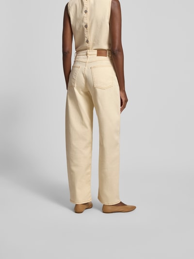 Frauenmodel trägt Straight Fit Jeans mit Ziernähten von BAUM & PFERDGARTEN aus Elastischer Baumwoll-Mix in Creme mit 5-Pocket-Design und Knopf- sowie Reißverschluss, Ganzkörperansicht Rückansicht.