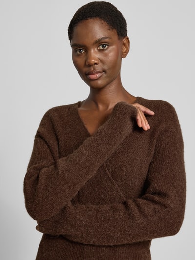 Frauenmodel trägt Strickpullover in Wickel-Optik Modell 'Bondie Hope' von MSCH Copenhagen in Braun, weiche Textur, Nahaufnahme Oberkörper. Damen Strickpullover, Woll-Mix, V-Ausschnitt, Regular Fit, Rückenlänge 50 cm, Ärmellänge 60 cm.