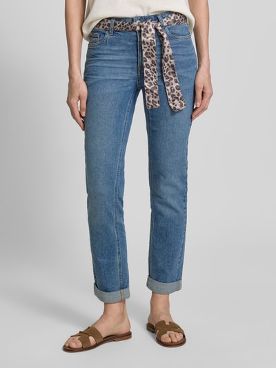 Vrouwenmodel draagt Slim Fit Jeans mit Bindegürtel und Saum mit Aufschlag van Zero, blauw, 5-pocketmodel, gestikt logo, knoop- en ritssluiting, strikceintuur, omslag, bandwijdte maat 36: 36 cm, binnenbeenlengte maat 36: 70 cm, nauwsluitend model, jeanslook. Detailaufnahme onderlichaam.