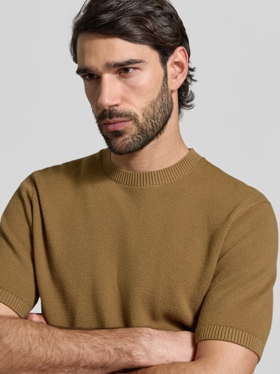 Männermodel trägt Regular Fit T-Shirt aus reiner Baumwolle von MCNEAL in Braun mit Strukturmuster, gerippter Stehkragen, Nahaufnahme Oberkörper.