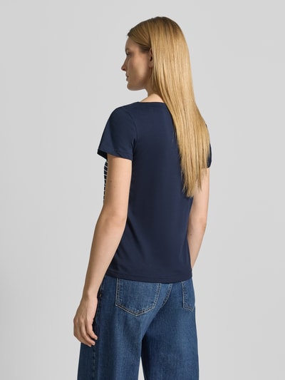 Frauenmodel trägt Regular Fit T-Shirt aus reiner Bio-Baumwolle von Tom Tailor in Dunkelblau mit Allover-Streifen und Label Print, Ganzkörperansicht Rückansicht.