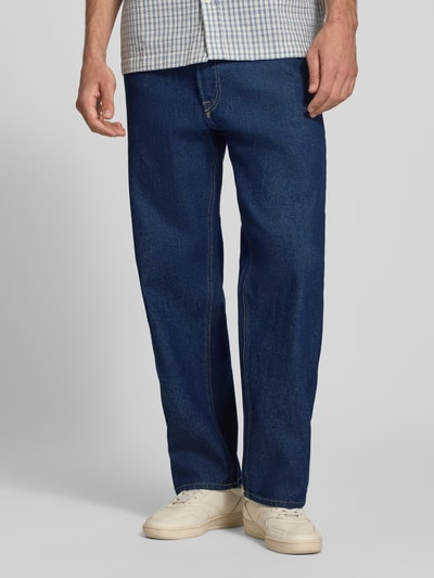 Männermodel trägt Loose Fit Jeans im 5-Pocket-Design Modell 'EDDIE' von JACK & JONES aus reiner Baumwolle, dunkelblauer Stoff, Nahaufnahme Unterkörper, Vorderansicht.