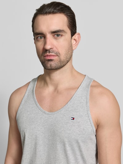Männermodel trägt Regular Fit Tank Top aus reiner Baumwolle im 3er-Pack von Tommy Hilfiger, Optik: Unifarben, Logo-Stitching, Nahaufnahme Oberkörper.