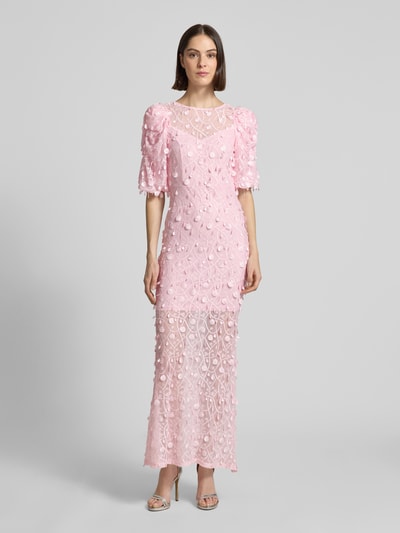 Modelka damska nosi różowe, długie maxikleid z aplikacjami Abendkleid mit Applikationen Modell 'BEATE' od YAS, krój slim fit, głęboki dekolt V, bufiaste rękawy, tylne wycięcie V, miękka faktura, Ganzkörperansicht von vorne.