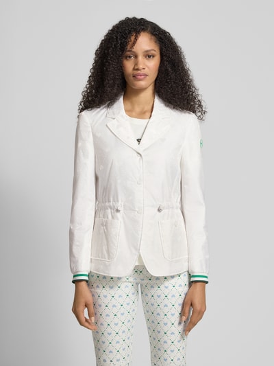 Frauenmodel trägt Regular Fit Blazer mit aufgesetzten Taschen von Marc Cain mit Allover-Motiv-Print, Logo-Applikation und Tunnelzug, Ganzkörperansicht von vorne.