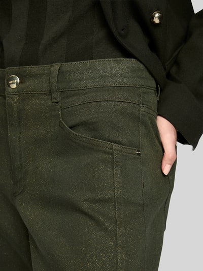 Kobiece modelka ma na sobie Relaxed Fit High Waist Jeans mit Eingrifftaschen von Marc Cain z mieszanki bawełny i elastanu, efekt błyszczący, wpuszczane kieszenie, ciemnozielone, szerokość w rozmiarze 36: 38 cm, długość wewnętrzna nogawki 71 cm, zbliżenie na górną część spodni