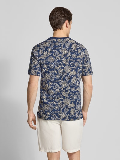 Männermodel trägt T-Shirt im Allover-Look mit Rundhalsausschnitt von Scotch & Soda, Regular-Fit, reine Baumwolle, Rückenlänge 70 cm, Ganzkörperansicht Rückansicht.