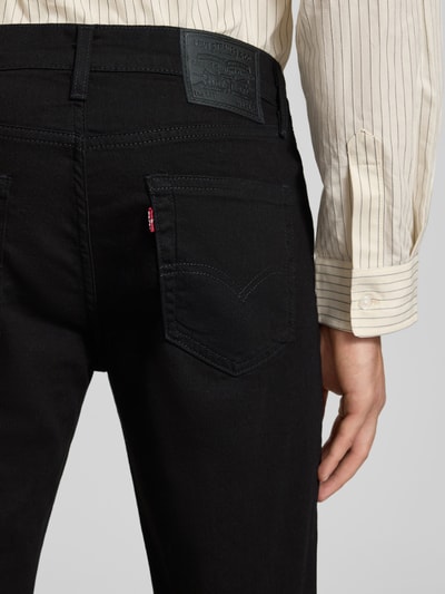 Männermodel trägt Slim Fit Jeans Modell '511®' von Levi's® aus schwarzem Baumwoll-Mix mit Stretch-Anteil, Label-Detail, Detailaufnahme Rückansicht.