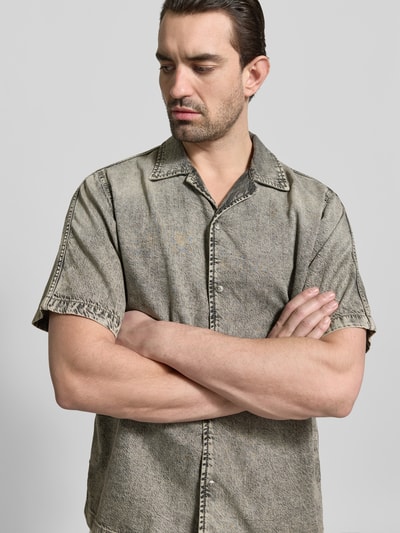 Männermodel trägt Regular Fit Jeanshemd mit Lyocell-Anteil von Diesel, Baumwoll-Lyocell-Mix, Reverskragen, Kurzarm, Nahaufnahme Oberkörper.