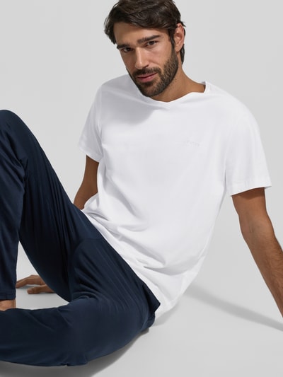 Männermodel trägt weißes Herren T-Shirt mit V-Ausschnitt im 2er-Pack Modell 'ComfortS' von BOSS, reine Baumwolle, gerader Schnitt, Unifarbenes-Design, Label-Stitching, Nahaufnahme Oberkörper.