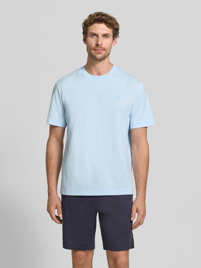 Męski model trägt Regular Fit T-Shirt aus reiner Baumwolle von Lacoste, Herren T-Shirt w jasnoniebieskim kolorze, gładka tekstura, Ganzkörperansicht von vorne.