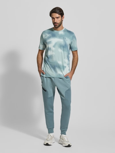 Männermodel draagt T-Shirt im Allover-Look mit Logo van Under Armour, blauw met witte tinten, regular fit, ronde hals, stretchmateriaal, alloverprint, volledige lichaamsaanzicht van voren.