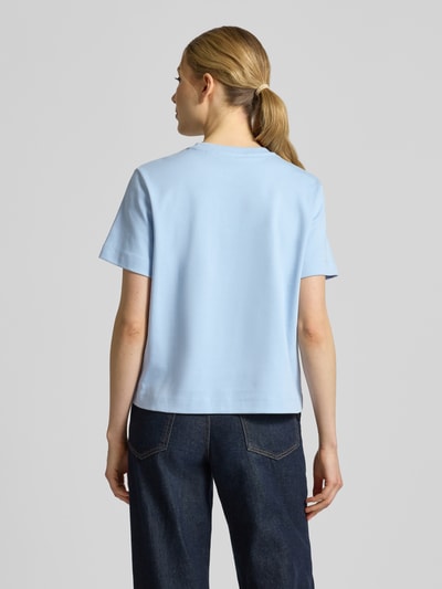 Modelka prezentuje damski t-shirt Regular Fit T-Shirt aus reiner Baumwolle Modell 'SARA' von Vero Moda, efekt: jednolity kolor, wyhaftowane logo, okrągły dekolt, krótki rękaw, wykończenie materiału: dżersej, bawełna. Ganzkörperansicht Rückansicht