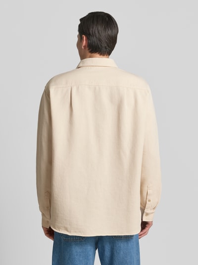 Männermodel trägt Regular Fit Freizeithemd mit Label-Patch von American Vintage aus Reine Baumwolle in Beige, Rückenlänge 77 cm, Schulterbreite 50 cm, Ärmellänge 66 cm, Kentkragen, Knopfleiste, Ganzkörperansicht Rückansicht.