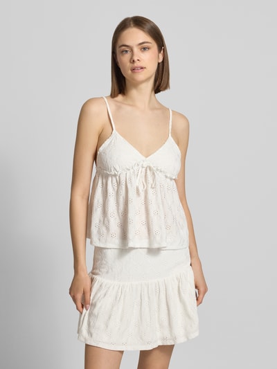 Kobiece modelka nosi Babydoll-Top mit Schößchendetail und Lochstickerei od REVIEW, mieszanka materiałów z dodatkiem streczu, krój regular fit, baskinka, haft angielski, długość tyłu w rozmiarze S: 27 cm, jasny kolor, całościowy wzór z wycięciami, widok całej sylwetki z przodu.