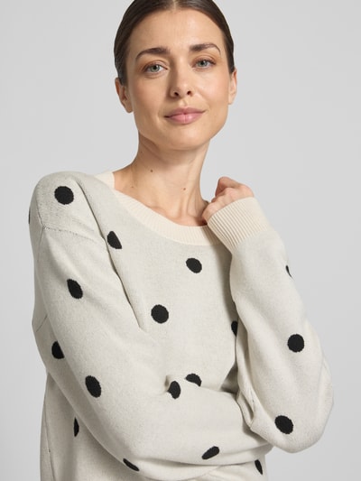 Frauenmodel trägt Strickpullover aus Viskose-Mix Modell 'Flow' von FREE/QUENT, cremefarben mit schwarzen Punkten, Nahaufnahme Oberkörper.