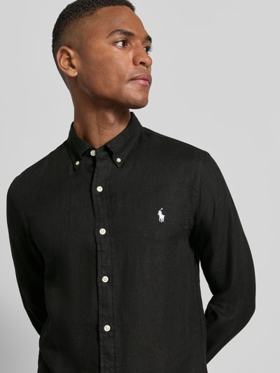 Mannelijk model draagt Slim Fit Vrijetijdsoverhemd uit puur linnen van Polo Ralph Lauren in effen zwart, logodetail, knoopsluiting, gevlamd garen, lange mouw, button-downkraag, mouwboord, licht afgeronde rompzoom, Nahaufnahme Oberkörper