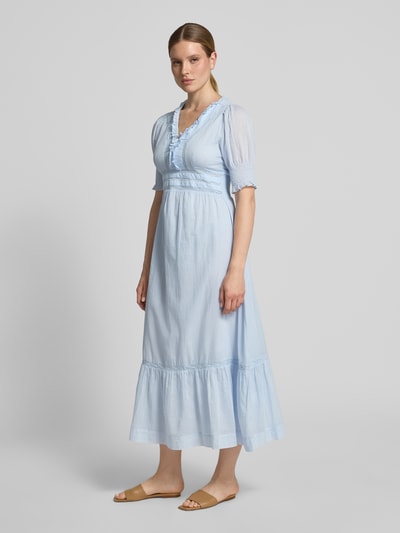 Frauenmodel trägt Damen Midikleid mit Rüschen und Häkelspitze Modell 'Alvina' von Neo Noir, Reine Baumwolle, Taillierter Schnitt, V-Ausschnitt, Smok-Detail an den Ärmeln, Rückenlänge bei Größe 36: 117 cm, Brustweite 43 cm, Ärmellänge 34 cm, hellblau, fließender Stoff, Ganzkörperansicht von vorne