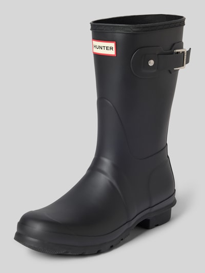 Produktfoto, Stiefel mit Label-Patch von Hunter in Schwarz mit Blockabsatz, strukturierter Sohle und Dornschließe, abgerundete Passform