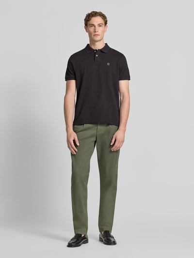 Mężczyznamodel nosi Regular Fit Poloshirt mit Label-Stitching von MCNEAL z bawełny, krój regular fit, listwa guzikowa, długość tyłu 70 cm w rozmiarze M, całopostaciowy widok z przodu
